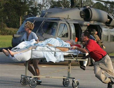 A woman is rushed to a temporary hospital after
being evacuated from the flood