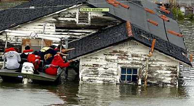 A group of Hurricane Katrina survivors climb off a roof and into a boat