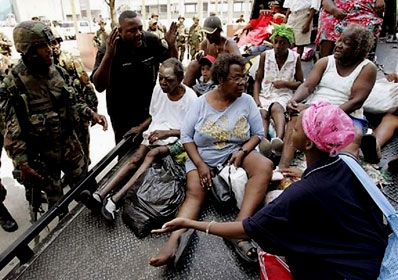 Hurricane Katrina survivors are transported on a flatbed truck